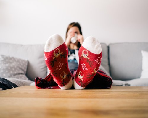 Person taking off formal office shoes revealing comfortable socks at home